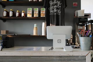 A store counter with products stacked on the wall.

point of sales marketing