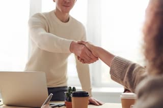 Two people shaking hands in a meeting