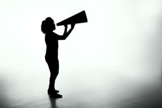 Person in silhouette shouting into megaphone