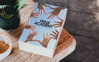 Penji academy yearbook on a wooden table